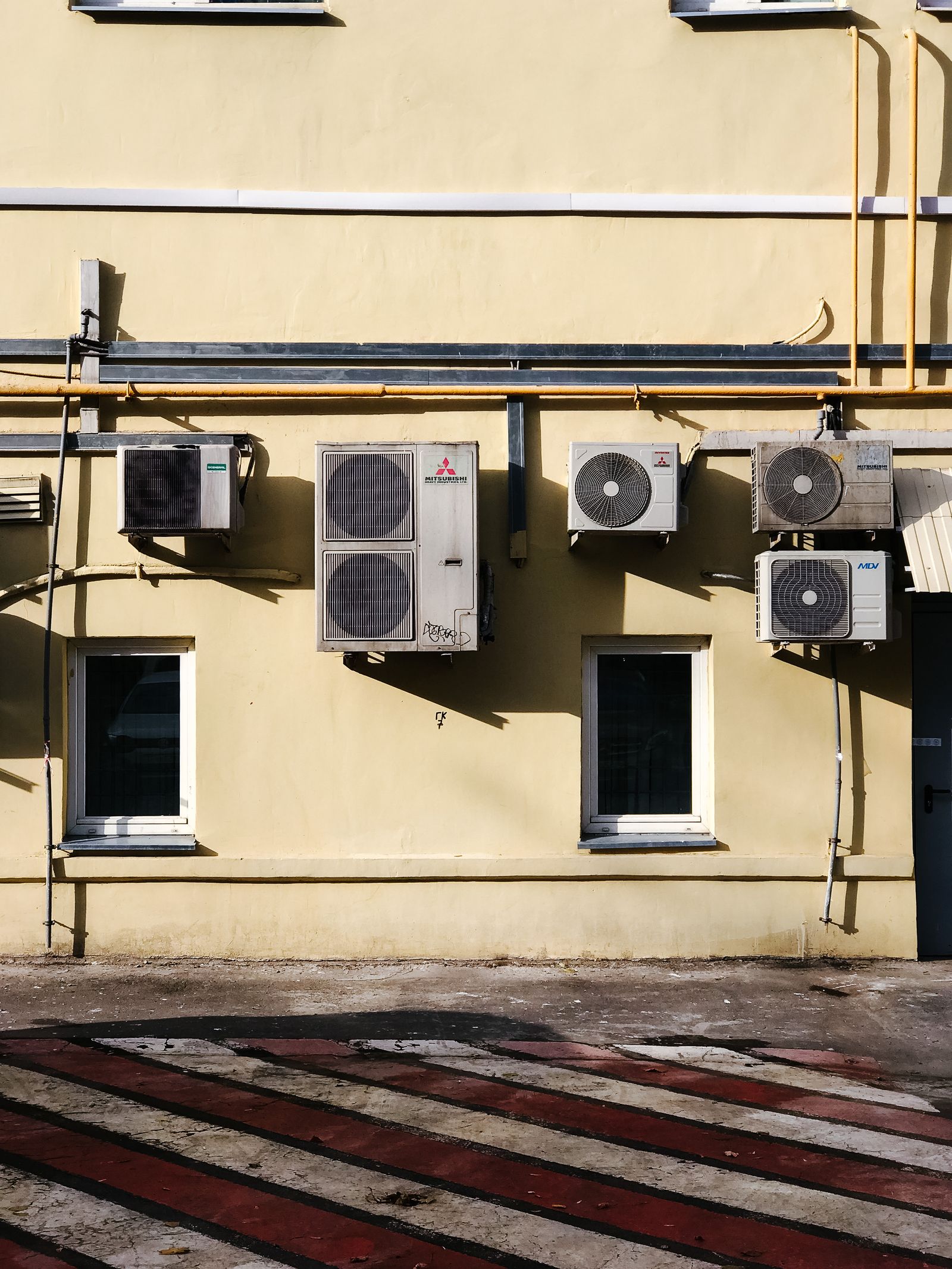 Residential outdoor AC condenser unit beside a home