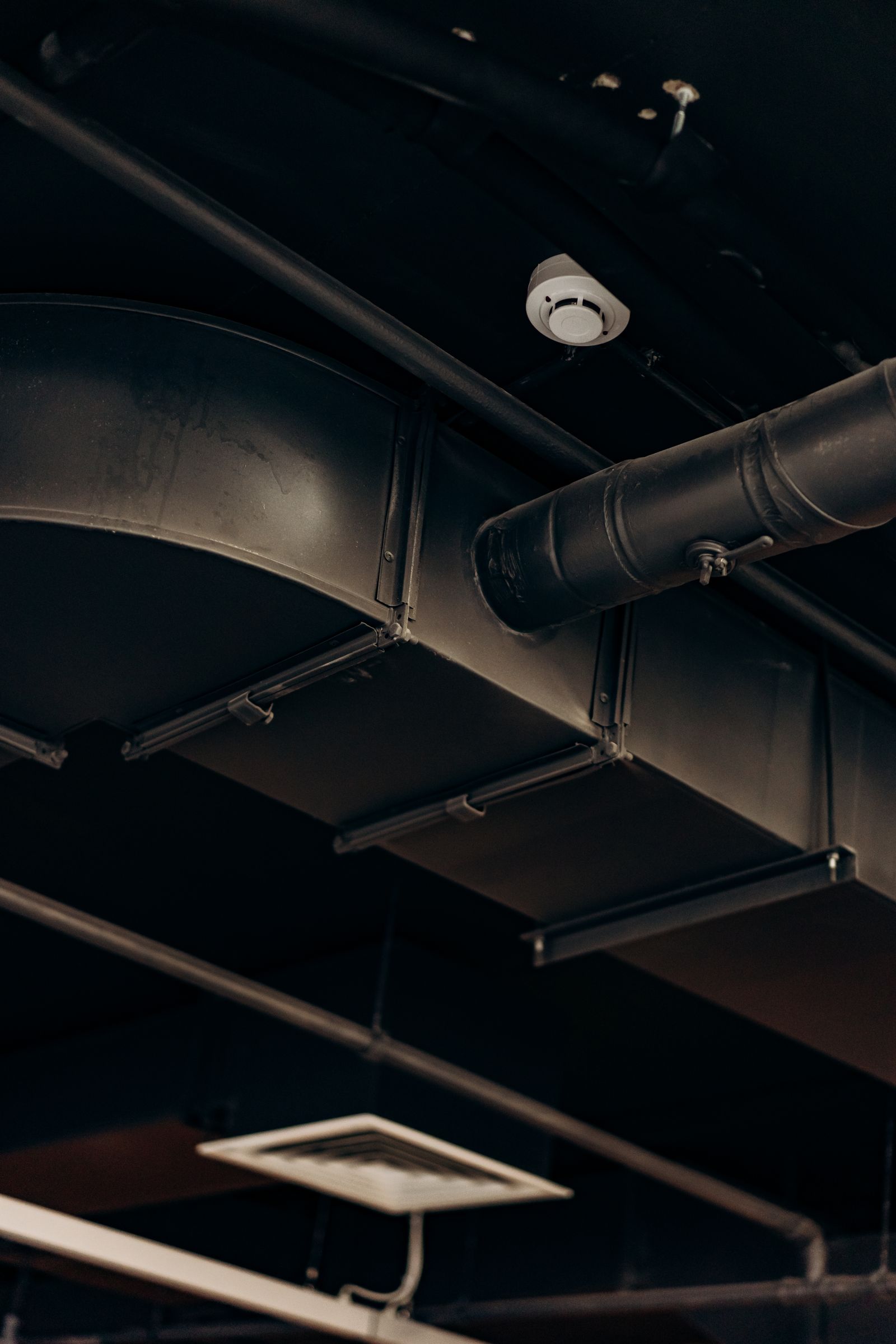 Exposed sheet-metal HVAC ductwork in a ceiling