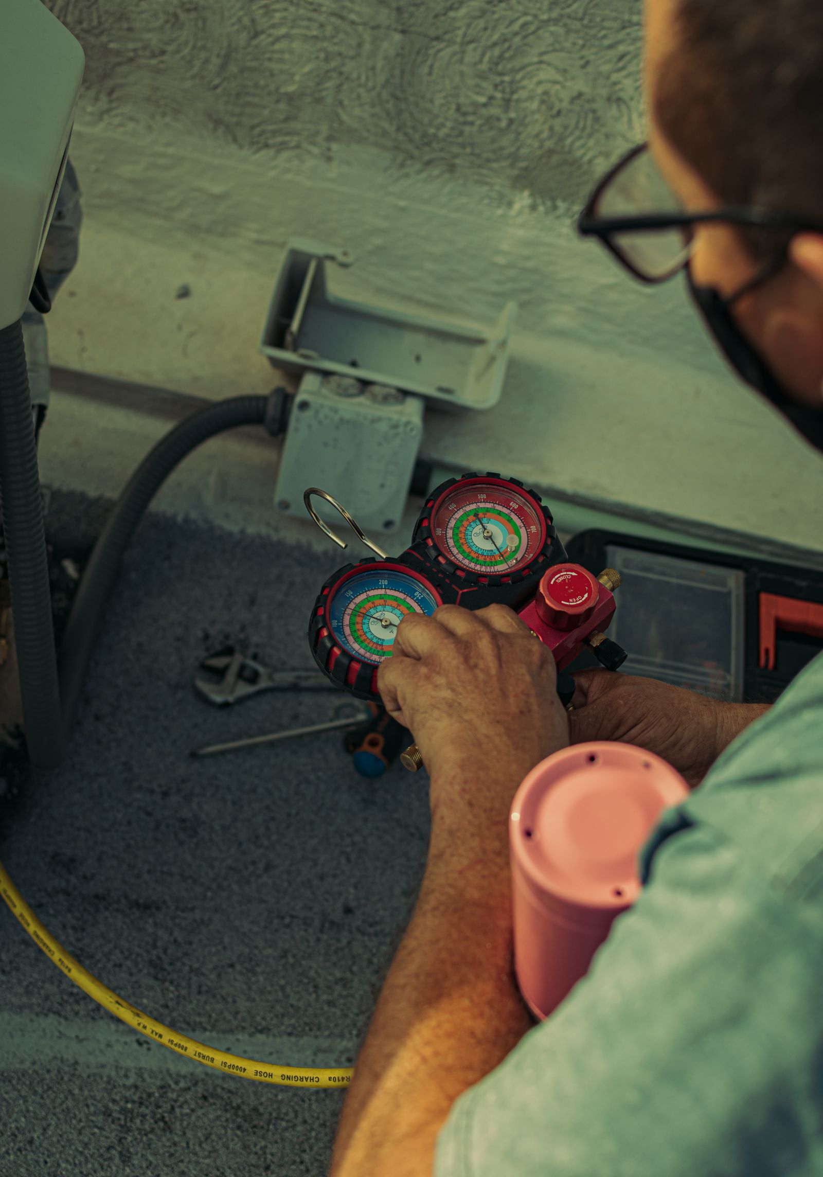 Technician checking pressure gauges on an air conditioner