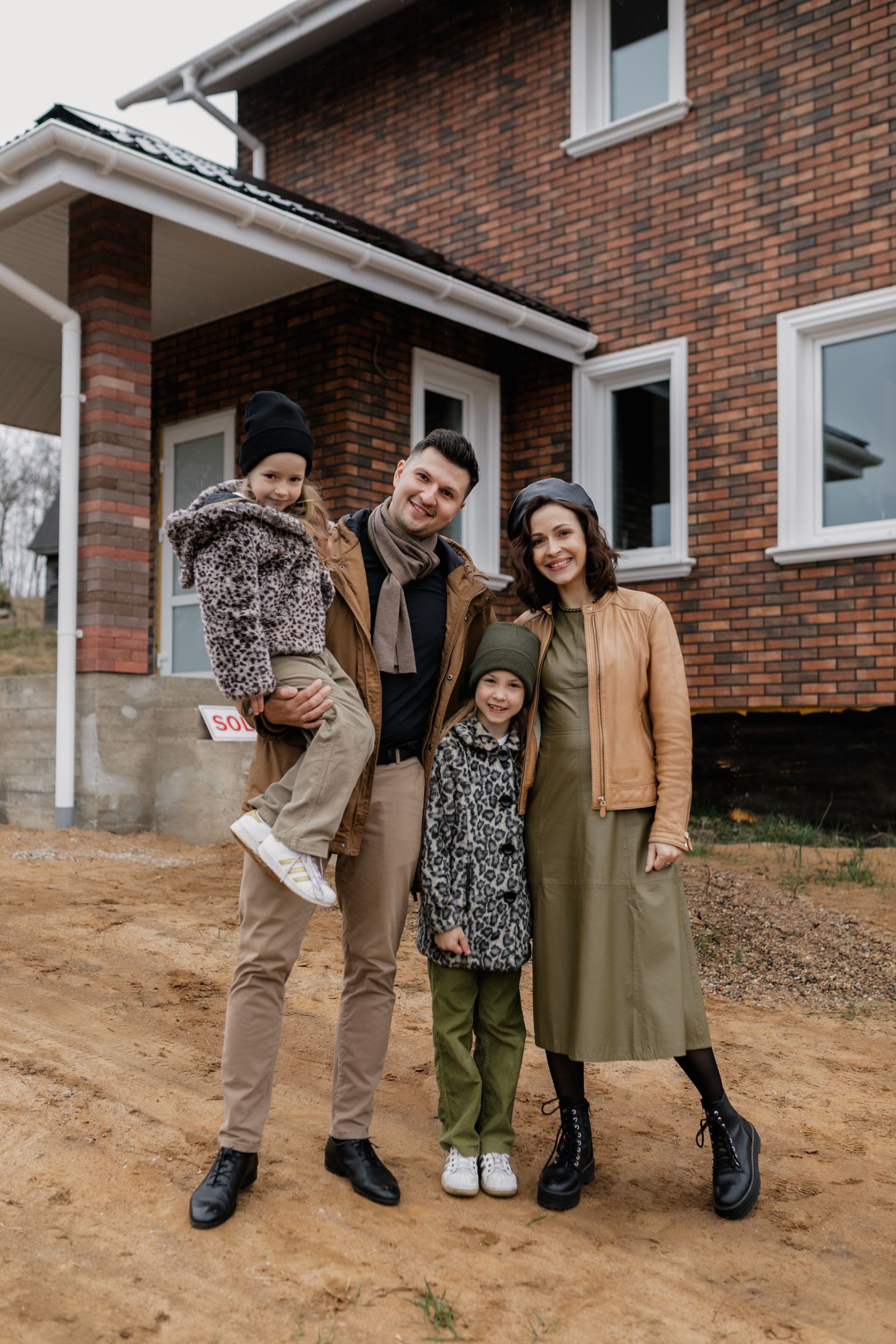 Happy family standing outside their new home