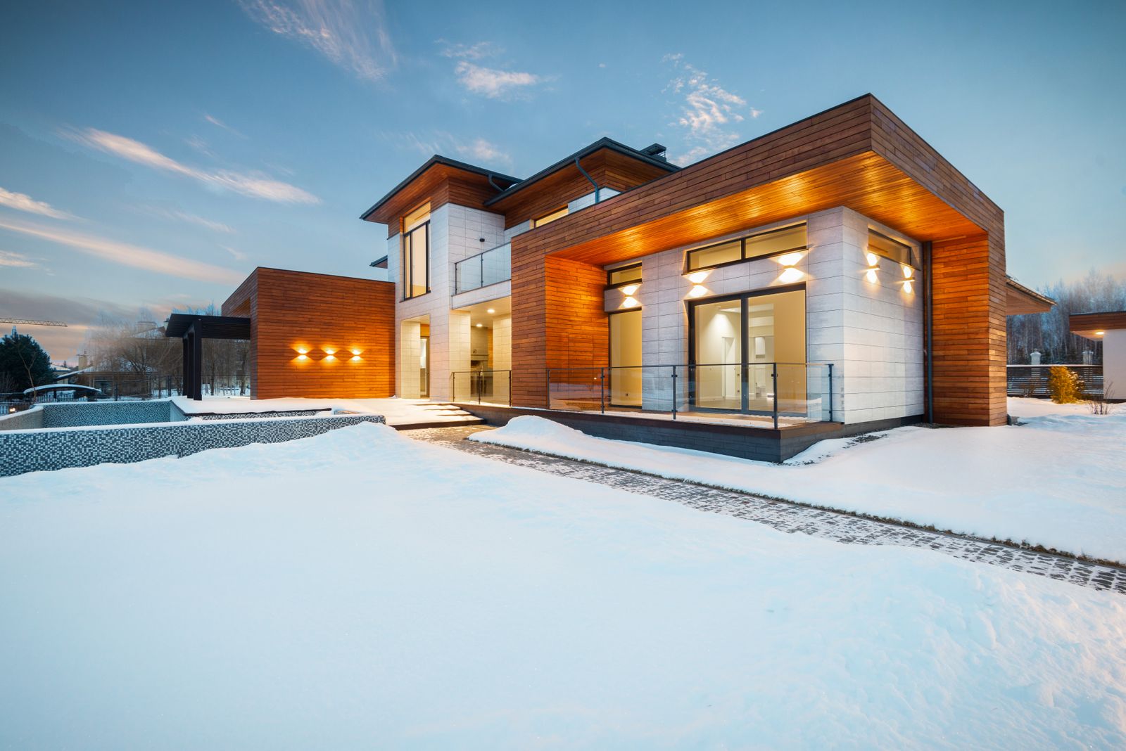 Snow-covered home exterior at dusk in winter
