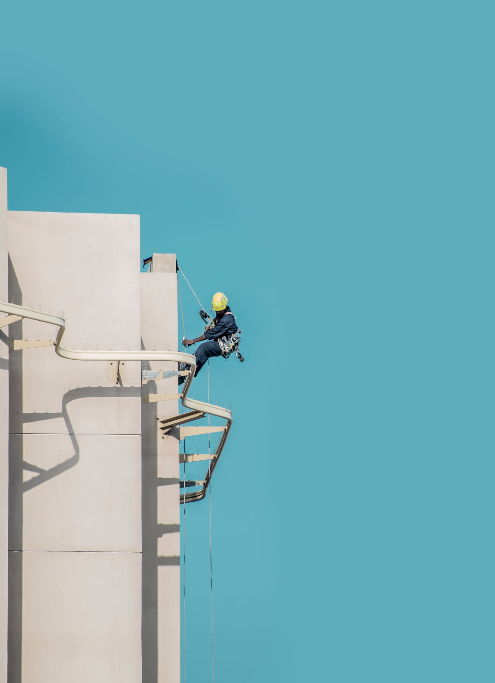 Worker with a ladder on a building rooftop